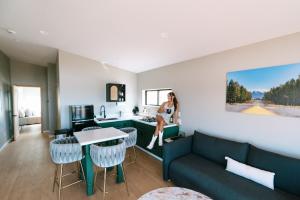 une femme assise sur un canapé dans un salon dans l'établissement Grand Canyon Stargazing Off-Grid, à Williams