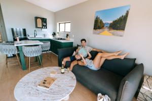 un homme et une femme allongés sur un canapé dans un salon dans l'établissement Grand Canyon Stargazing Off-Grid, à Williams