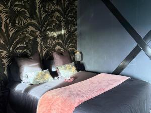 een bed met een roze deken en kussens in een kamer bij Hmm OH Oui - Studio With Sauna and More in Saint-Quentin