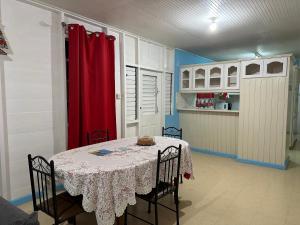 a dining room with a table and a red curtain at T.Cole’s Holiday Rental in Saint James