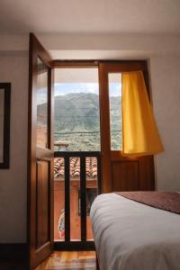 a bedroom with a bed and a window with a view at Shanti Hotel Pisac in Pisac