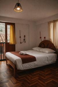 a bedroom with a large bed with a wooden headboard at Shanti Hotel Pisac in Pisac +14 photos