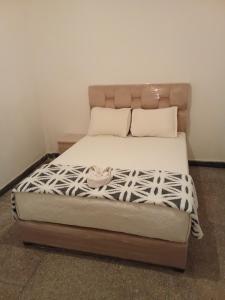 a bed with white sheets and pillows on it at Villa harhora in Temara