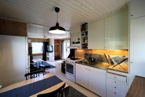 a kitchen with white cabinets and a dining table at Aurora Jukkasjarvi in Jukkasjärvi