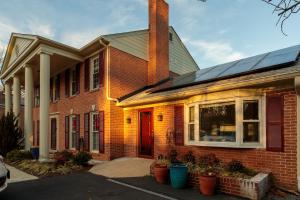 a brick house with solar panels on it at Bright, Spacious Home with Private Deck in Potomac