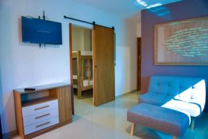 een woonkamer met een blauwe bank en een tv bij Gairaka 3 in Gaira