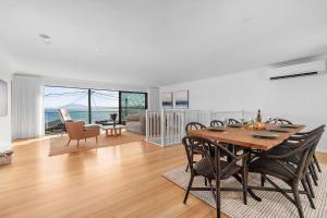 une salle à manger et un salon avec une table et des chaises dans l'établissement Panorama, Gerroa, South Coast, à Gerroa
