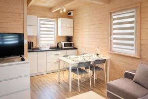 a kitchen and dining room with a table and chairs at Domeczki Blaneczki Wicie - domki letniskowe nad morzem in Wicie +28 photos
