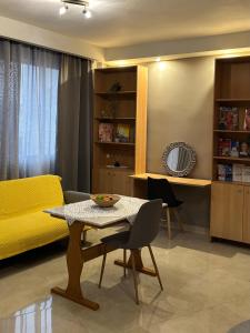 a living room with a table and a yellow couch at Downtown Studio 31 in Serres