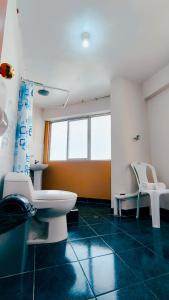 a bathroom with a toilet and two white chairs at Laguna Apartment in Huaraz