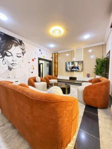 een woonkamer met banken en een muurschildering van een vrouw bij Lively - Maitama in Abuja
