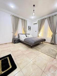 een slaapkamer met een bed in een kamer met ramen bij Lively - Maitama in Abuja