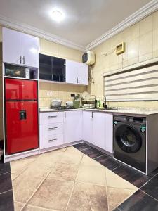 een keuken met een rode koelkast en een wasmachine bij Lively - Maitama in Abuja +8 foto's