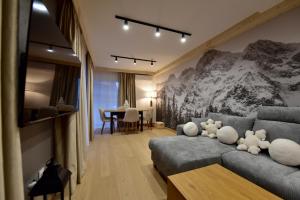a living room with a couch and a table at Wierchy Resort 21B by AWapartaments in Zakopane