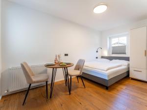 een slaapkamer met een bed, een tafel en stoelen bij Leni Top 2 in Dienten am Hochkönig