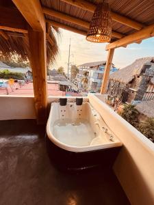 een badkuip die tegen de zijkant van een huis staat bij Punta Arena Surf Suites in Puerto Escondido