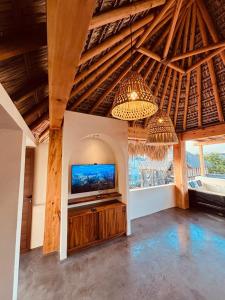 een woonkamer met een flatscreen-tv en een kroonluchter bij Punta Arena Surf Suites in Puerto Escondido +58 foto's
