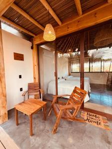 een slaapkamer met een bed, een tafel en stoelen bij Punta Arena Surf Suites in Puerto Escondido