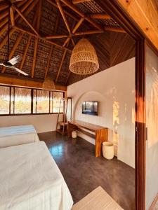 een slaapkamer met 2 bedden en een bank erin bij Punta Arena Surf Suites in Puerto Escondido