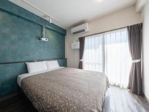 a bedroom with a bed and a large window at Hote Io Lite in Nago