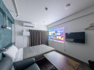 a hotel room with a bed and a flat screen tv at Hote Io Lite in Nago +82 photos