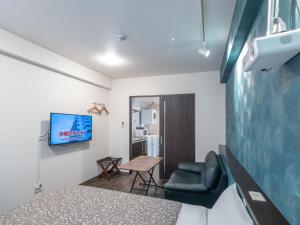 Camera con letto, TV e sedia di Hote Io Lite a Nago