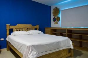 een slaapkamer met een bed en een blauwe muur bij Gairaka 3 in Gaira
