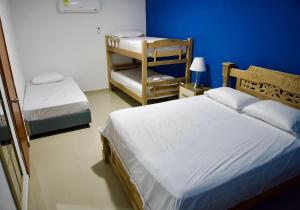 een slaapkamer met 2 bedden en een blauwe muur bij Gairaka 3 in Gaira