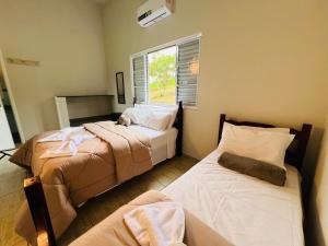 een slaapkamer met 2 bedden en een kat op het bed bij Pousada Horizonte da Canastra in São Roque de Minas +85 foto's