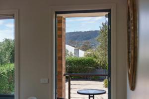 a door to a balcony with a view of a table at Spacious beachside family home in Rosebud