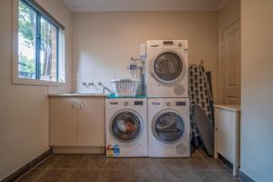 a laundry room with two washing machines and a sink at Spacious beachside family home in Rosebud