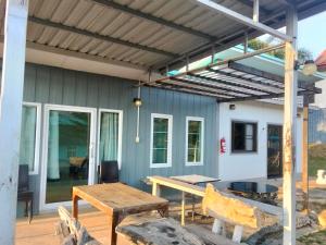 awning over a patio with a table and bench at บ้านไร่เรืองแสง in Ban Thung Samo