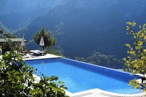 a swimming pool with a view of a mountain at Kabak Avalon Bungalows in Faralya