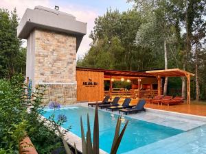 een zwembad met stoelen en een paviljoen bij Complejo Malama Kai in Mar de Cobo