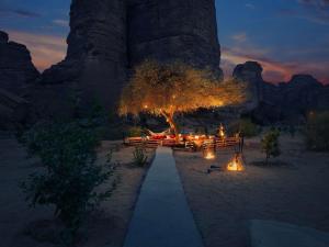 um caminho no deserto com uma árvore e luzes em Shaden Resort em Al Ula
