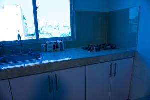 een aanrecht met een wastafel en een raam bij Gairaka 4 in Gaira