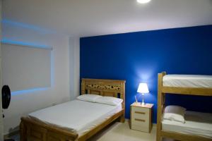 een slaapkamer met 2 stapelbedden en een blauwe muur bij Gairaka 4 in Gaira