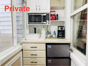 eine Küche mit weißen Schränken und einer Mikrowelle in der Unterkunft Barkerhouse 2# unit-heart of oldtown in Niagara on the Lake