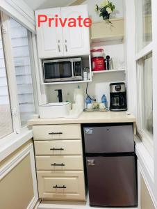 een keuken met witte kasten en een zwarte vaatwasser bij Barkerhouse 2# unit-heart of oldtown in Niagara on the Lake