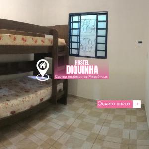 una stanza con due letti a castello e un cartello che dice sushdir durka di Hostel Diquinha a Pirenópolis