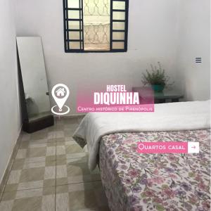 una camera da letto con un letto e un cartello con la scritta music drumulum di Hostel Diquinha a Pirenópolis