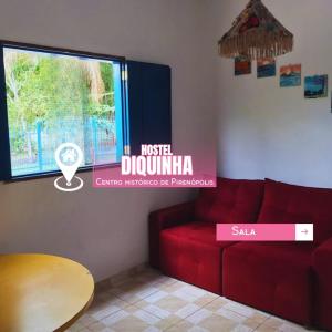 un soggiorno con divano rosso e finestra di Hostel Diquinha a Pirenópolis