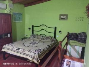 una camera da letto con un letto in una stanza con pareti verdi di Nicolas Nancy Ricardo a Las Grutas