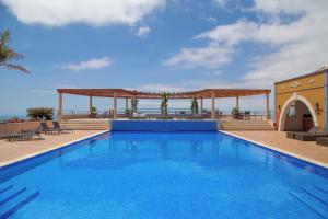 a large blue swimming pool with a gazebo at Balancal Apartments and Villas Palheiro Village in Funchal +209 photos