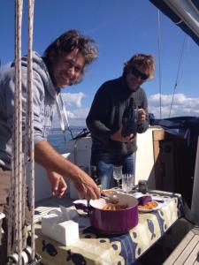 two men standing on a boat with a bowl of food at Cavallino House Boat in Cavallino-Treporti
