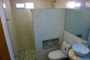 een badkamer met een douche, een toilet en een wastafel bij Gairaka 5 in Gaira