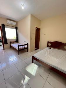 een slaapkamer met twee bedden en een raam bij Suítes litoral in Caraguatatuba