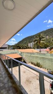 uitzicht op het strand vanaf het balkon van een gebouw bij Suítes litoral in Caraguatatuba