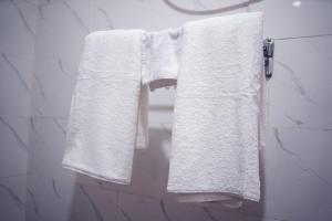 two white towels hanging on a towel rack in a bathroom at Nafik Suites in Rayfield +18 photos