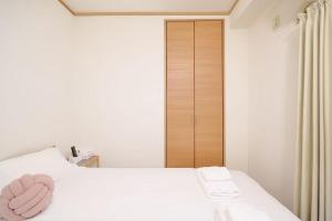 ein Schlafzimmer mit einem Bett und einem rosa Handtuch darauf in der Unterkunft 3 min JR Direct to Skytree Asakusa Shinjuku Sea Heim in Tokio